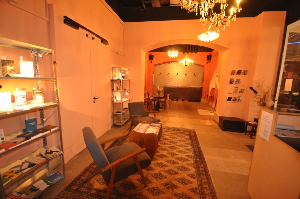 C'est une photo de notre foyer du sous-sol. Il y a des lustres et des fauteils. Les parrois sont oranges.