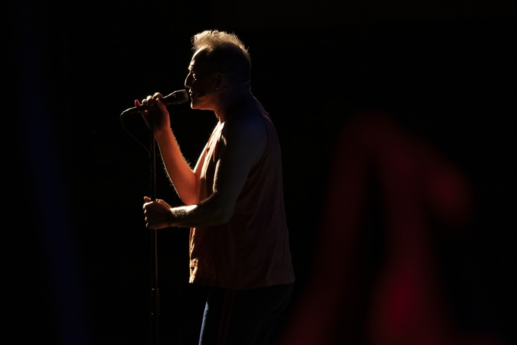 dans le noir une silhouette d'une personne en train de chanter.