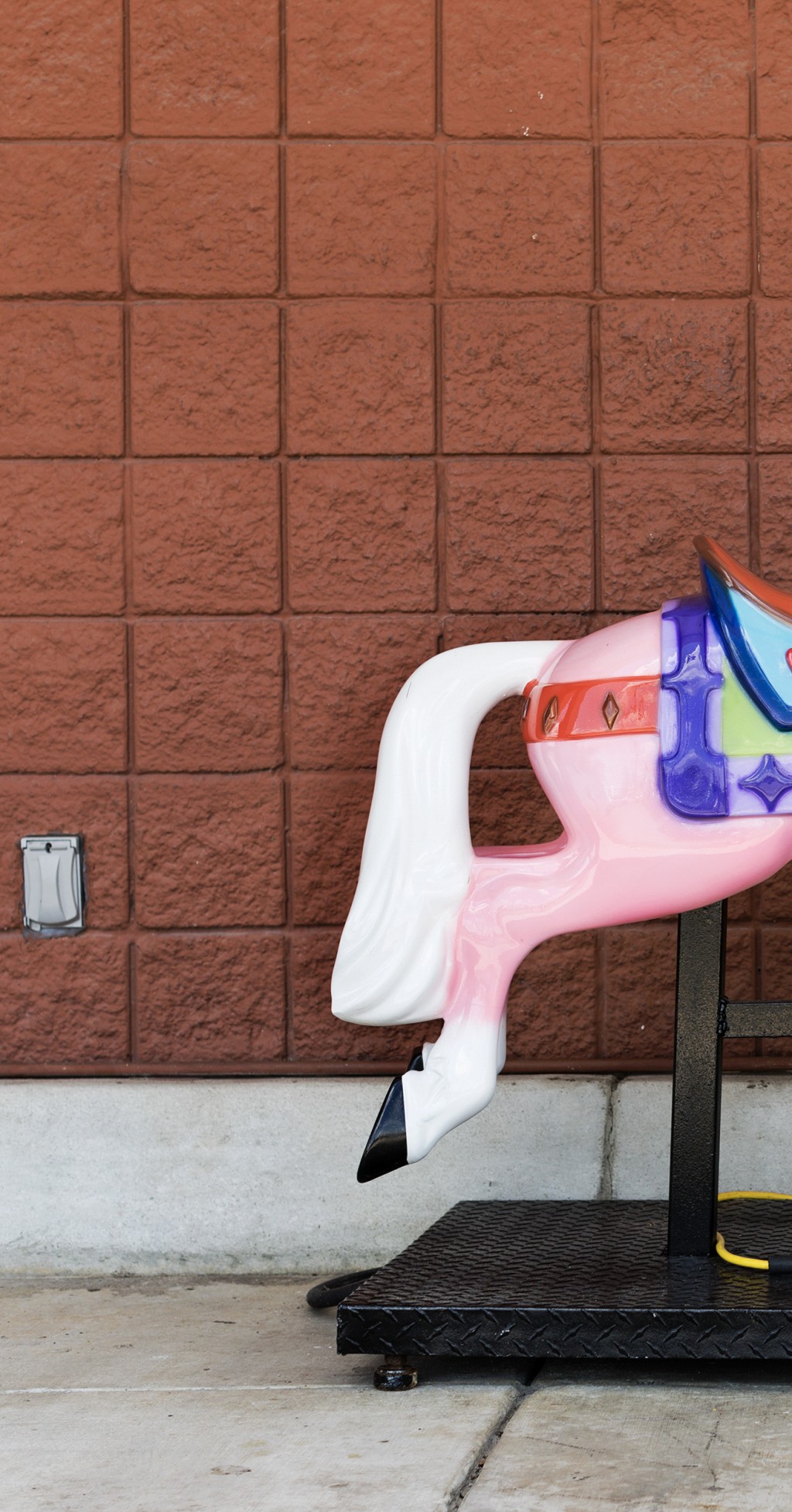 C'est l'arrière train d'un cheval de manege en plastique coloré. Celui qu'on peut faire fonctionner avec une pièce, mais la prise est debranchée