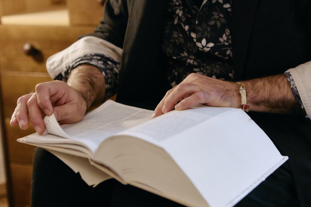 Ce sont les mains de quelqu'un en train de feuilleter un livre.