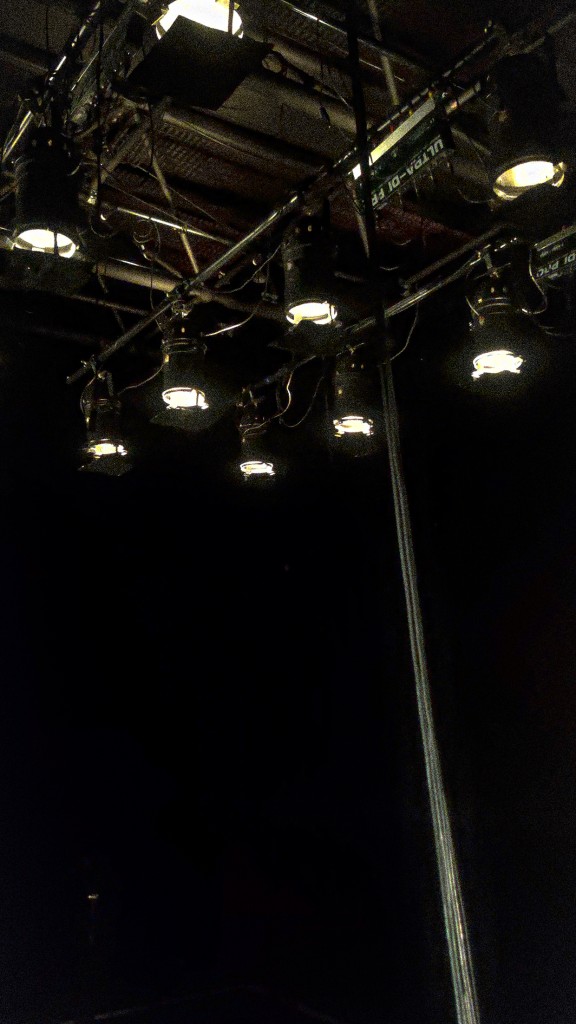 Des projecteurs accrochés en haut. La lumière est blanche.