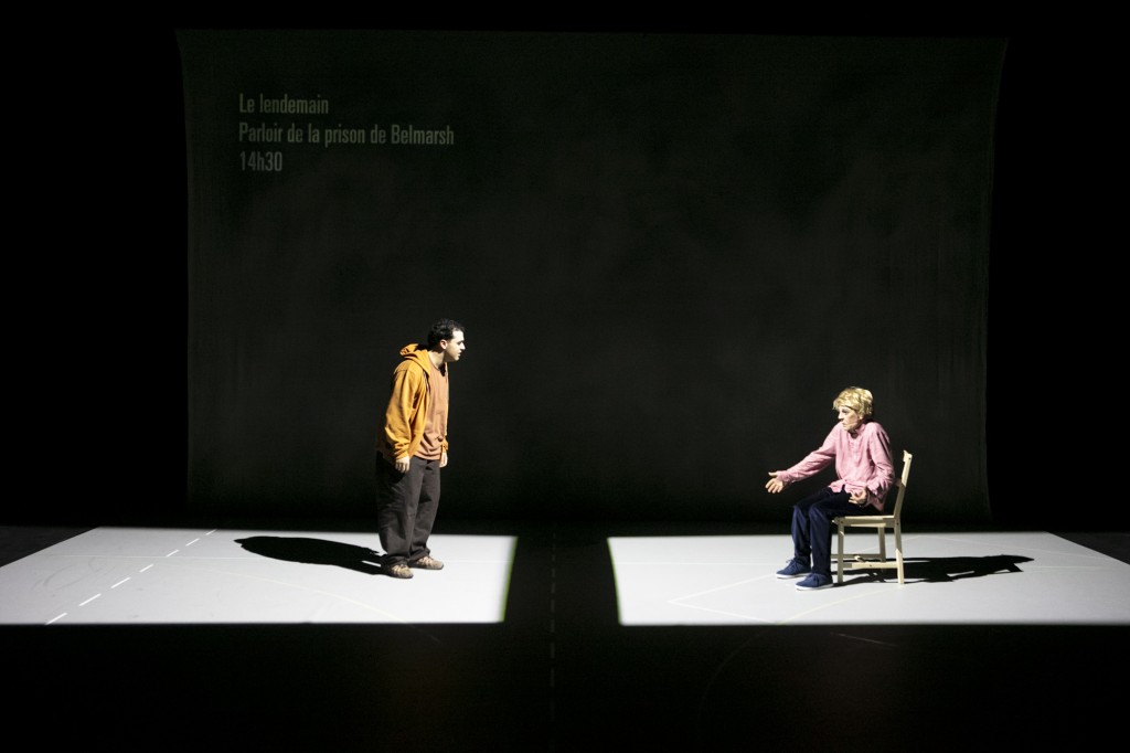 Deux personnes dans deux carrés lumineux differents. Celle de gauche est debout, celle de droite est assise sur une chaise.