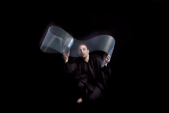 C'est une photo de l'artiste du spectacle en train de jouer avec un rouleau d'une matiere qui produit un effet optique très bizarre. Comme de formes geometriques dansantes.