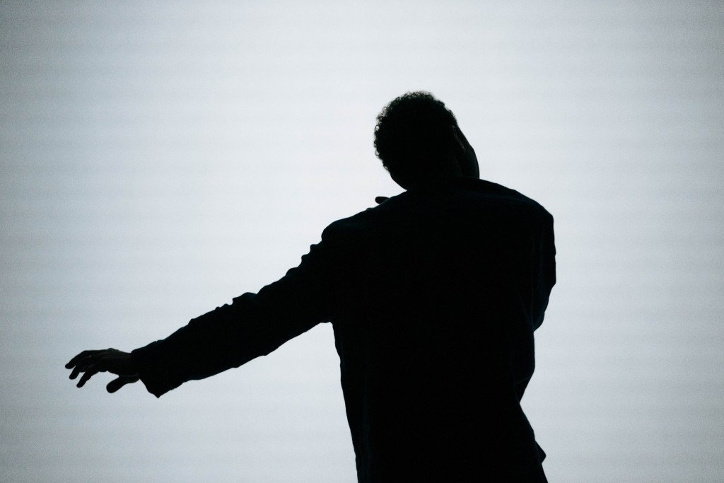 Une silhouette noir en train de danser. On voit pas son visage.
