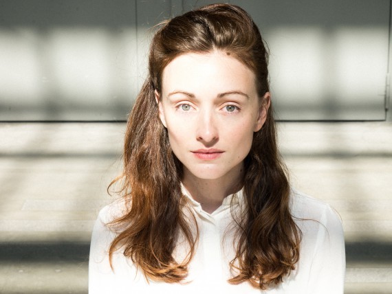 C'est le portrait de Delphine Hecquet, elle porte une chemise blanche, elle a les cheveux long.