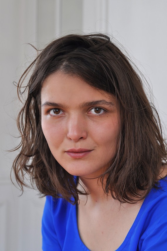 C'est le portrait de Mathilde Morel, elle porte un t-shirt bleu, elle a les cheveux bruns.